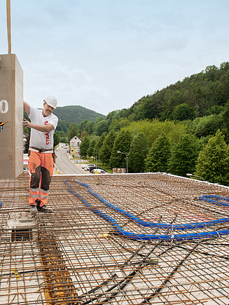 Zwei Bauarbeiter befüllen ein Fundament mit Beton