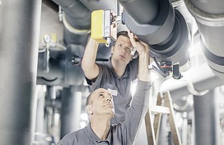 Foto zwei Mitarbeiter überprüfen Rohrleitungen