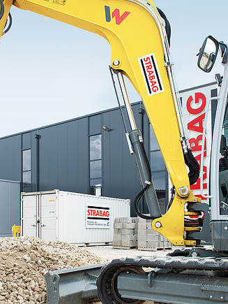 Lehrling im Bagger bewegt Steine