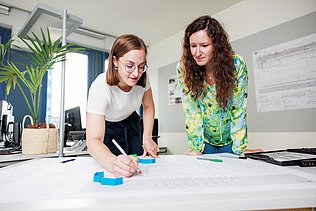 Mitarbeiterin prüft Zeichnung