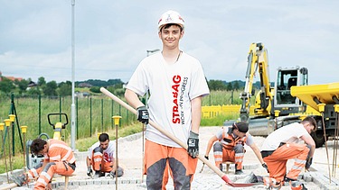 Foto fünf Personen, der vordere mit Helm schaut in Kamera