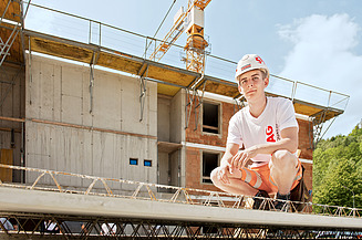 Lehre Betonbau Foto Auszubildender vor einem Rohbau