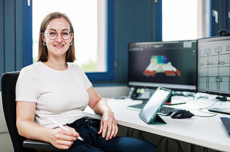 Foto drei Mitarbeitende besprechen einen Bauplan