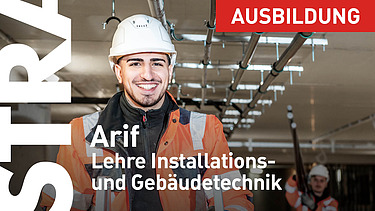 Lehrling steht mit Schaufel vor LKW