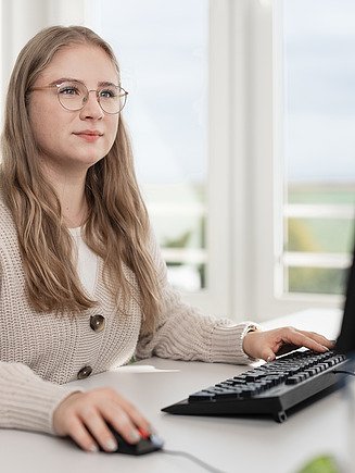 Foto vier Mitarbeitende mit Laptop und Ipad am Besprechungstisch