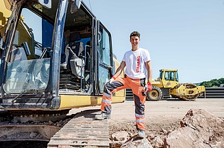 Foto Auszubildender spannt Schnur für Pflasterarbeiten