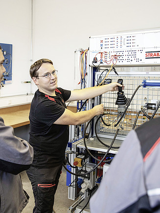 Foto drei Mitarbeiter vor technischem Gerät