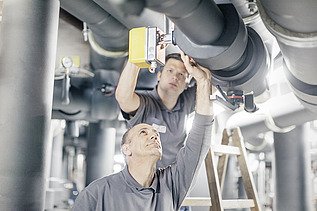 Foto zwei Mitarbeiter überprüfen Rohrleitungen