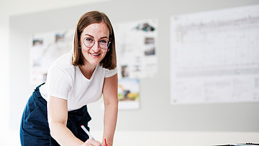Foto ein Mitarbeiter vor zwei Bildschirmen mit Bauplänen