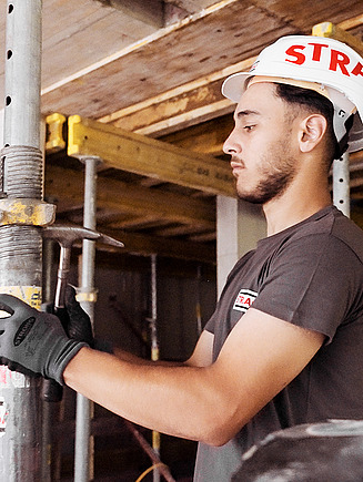 Foto zwei Bauarbeiter beim Einschlagen eines Holzpflocks